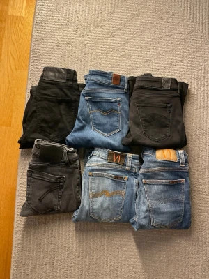6 par jeans i olika färger och tvättar - Säljer ett paket med sex par jeans i svart, grått och olika blå tvättar. Några har klassiska kontrastsömmar och läderpatch bak, vissa med diskreta detaljer. Perfekta för dig som gillar stilrena och tidlösa jeans i olika nyanser.