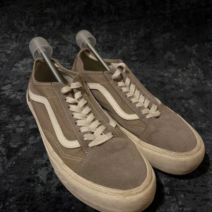 Vans Old Skool sneakers - Säljer ett par Vans Old Skool sneakers med klassisk vit sidostripe och ovandelen är i mocka och canvas, och sulan är i gummi med det ikoniska rutmönstret undertill. Storlek 44, dom är i fint skick.