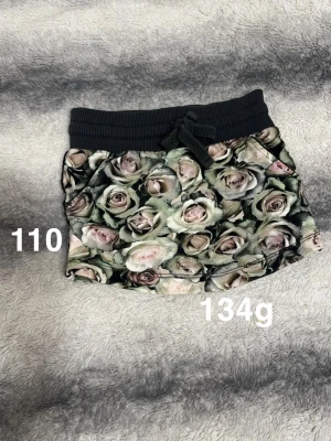  blommig kjol med snörning - Supersöt kjol med blommigt mönster i dova toner. Kjolen har bred svart resårmidja och snörning framtill för extra stilpoäng. Perfekt för dig som gillar en chill och trendig look🌸.Fint använt skick. Storlek 110 