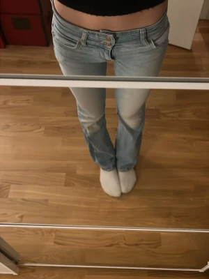 Ljusblå bootcut jeans från Bershka - Säljer ett par ljusblå jeans från Bershka med bootcut-modell och låg midja.  säljer för de börjar bli för små!                                                                          Säljer ganska dyrt då orginalpris 520kr och är i alldeles bra skick. ❤️                                                                                   Midja: 30cm.                                                                                             Innerbenslängden: 76cm!       