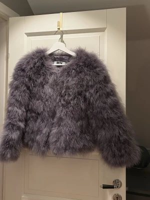 Lila fluffig pälsjacka från DSA - Säljer en supermjuk och fluffig lila pälsjacka från DSA. Jackan har lång ärm, croppad passform och är tillverkad i syntetiskt pälsmaterial. Perfekt för dig som vill sticka ut och hålla dig varm med stil.
