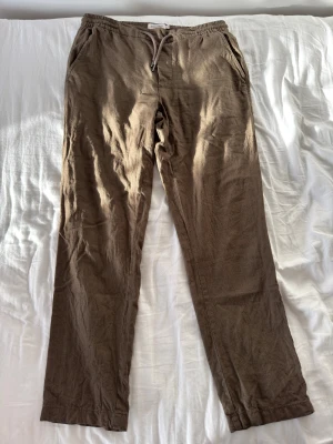 Bruna linnebyxor från Dressmann  - Snygga bruna linnebyxor från Dressmann i storlek M. De har elastisk midja med snörning, sidfickor och bakfickor med knapp. Aldrig använda🙂Pris kan diskuteras!