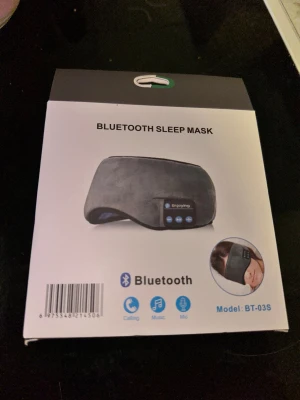 Bluetooth Sleep Mask Bluetooth Sovmask - Bluetooth Sleep Mask från Enjoying kombinerar bekväm ögonmask med trådlösa hörlurar. Perfekt för musik, samtal och handsfree-funktioner under vila. Mjuk design, inbyggd mikrofon och volymkontroller. Produkten är ny i förpackning, utan synligt slitage.Bluetooth sovmask. Perfekt för en god natts sömn. 🎁 