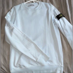 Vit sweatshirt från Stone Island - Vit långärmad sweatshirt från Stone Island inga märken eller fel utan är i perfekt skick helt oanvänd i storlek M. Diskutera gärna priset med mig. Paxar inget år någon den som betalar först får varan!