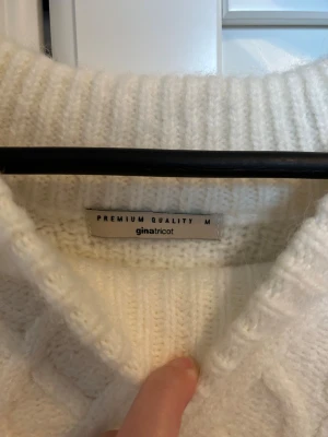 Vit stickad tröja från Gina Tricot - Mysig vit stickad tröja från Gina Tricot i storlek M. Tröjan har ett snyggt flätmönster framtill och på ärmarna, samt bred ribbad kant vid hals och muddar. Passformen är loose och den har långärmade ärmar. Perfekt för kyliga dagar. I nyskick 🤍