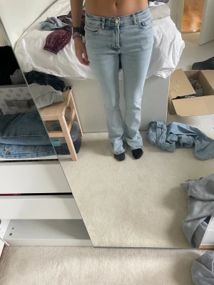 Ljusblå low flare jeans XS - Säljer ett par ljusblå low flare jeans med låg midja och klassisk femficksdesign. Jeansen har en snygg utsvängd passform nedtill och är tillverkade i mjukt denimtyg. 