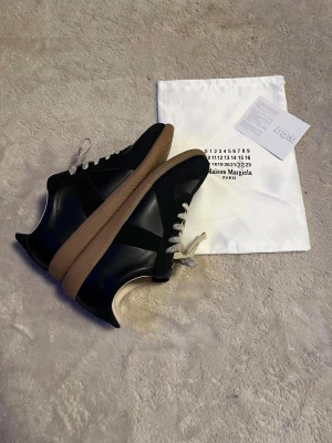 Maison Margiela GAT – Storlek 45 – Helt nya - Säljer ett par Maison Margiela German Army Trainers (GAT) i storlek 45. Skorna är helt oanvända eftersom storleken inte passade.  Skick: Nya, 9,5/10 Storlek: 45 Modell: GAT Nypris: 8200  Exklusiva och stilrena sneakers i premiumläder med klassisk Margiela-design. Skickas snabbt och väl emballerat.