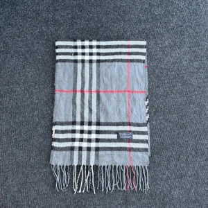 Burberry scarf - Burberry-scarf som är 100% äkta. Mindre defekter kan förekomma enligt bild men inget märkvärdigt då de är vintage. Snabb leverans och trygg handel då vi har 7 års erfarenhet i branschen. Vid frågor eller bud, skicka gärna ett meddelande. 1017