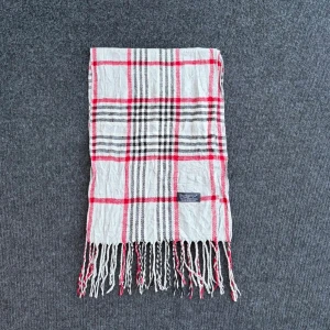 Burberry scarf - Burberry-scarf som är 100% äkta. Mindre defekter kan förekomma enligt bild men inget märkvärdigt då de är vintage. Snabb leverans och trygg handel då vi har 7 års erfarenhet i branschen. Vid frågor eller bud, skicka gärna ett meddelande. 1007