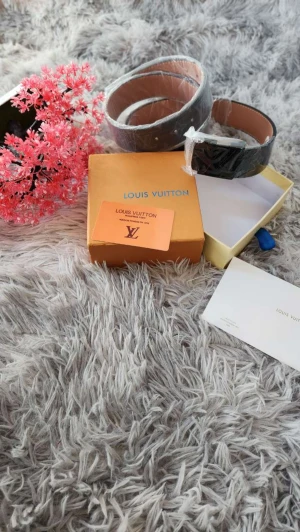  svart skärp i skinn - Snyggt svart bälte med klassiskt monogrammönster i grått. Bältet är gjort i  skinn med beige insida och har en stilren, rektangulär form. Perfekt accessoar för att lyfta din outfit med exklusiv känsla.