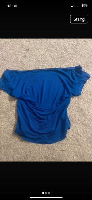 Blå offshoulder topp från SHEIN - Snygg blå offshoulder topp från SHEIN i storlek S. Tunn och mjuk, med bred halsringning som går ner över axlarna. Perfekt för dig som gillar en enkel men ändå trendig look. Materialet är lätt och stretchigt, vilket gör den skön att bära.