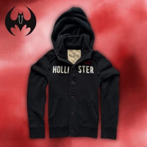 Svart hollister Hoodie / Kofta - Svart Kofta från Hollister med knappar och broderad vit text på bröstet | Size M/L | Längd: 68cm Axelbredd: 46cm Armlängd: 74cm  | Passar mellan för 172-195 cm