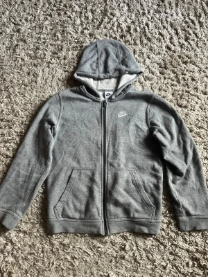 Nike tech hoodie - Grå Nike tech hoodie. Passar de som är mellan 147-158cm långa. Fick den i present för 2 år sedan. Jag använde den i början men har inte rört den på 1 år. Inte fast pris.