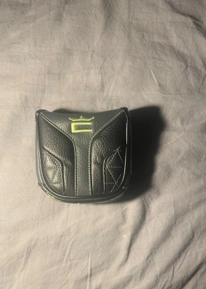 Putter headcover  - Säljer en putter headcover från Cobra. Den är i bra skick och passar de flesta Cobra putters. Perfekt för att skydda din putter på golfbanan!