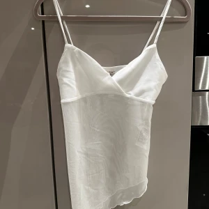 Vit mesh topp från Nelly med smala axelband🤍 - Säljer en helt oanvänd topp från Nelly i storek xs. Det är ett sneskuret linne i mesh, superfräsch 