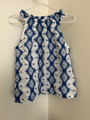 Somrig festtop - Snygg festtopp i en halterneck-modell, helt nytt skick utan prislapp. Storlek XS. 