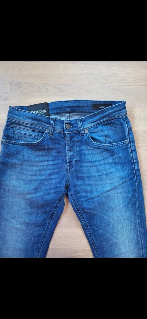 DONDUP Blå skinny jeans 29 - Snygga blå skinny jeans från DONDUP modellen George. Storlek 29. Femficksmodell. Ljus tvätt. Small passform. Mjuk demin tyg med stretch. Låg midja. Knappgylf. Tillverkade i Italien. Mycket bra skick. 