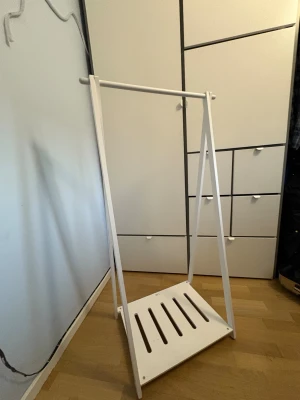 JOX klädställning - Stilren vit klädställning från JOX, perfekt för barnrum eller hall. Stabil konstruktion med plats för galgar och hylla för skor eller förvaring. Mindre bruksspår men i gott skick. Enkel att montera och passar i de flesta hem.