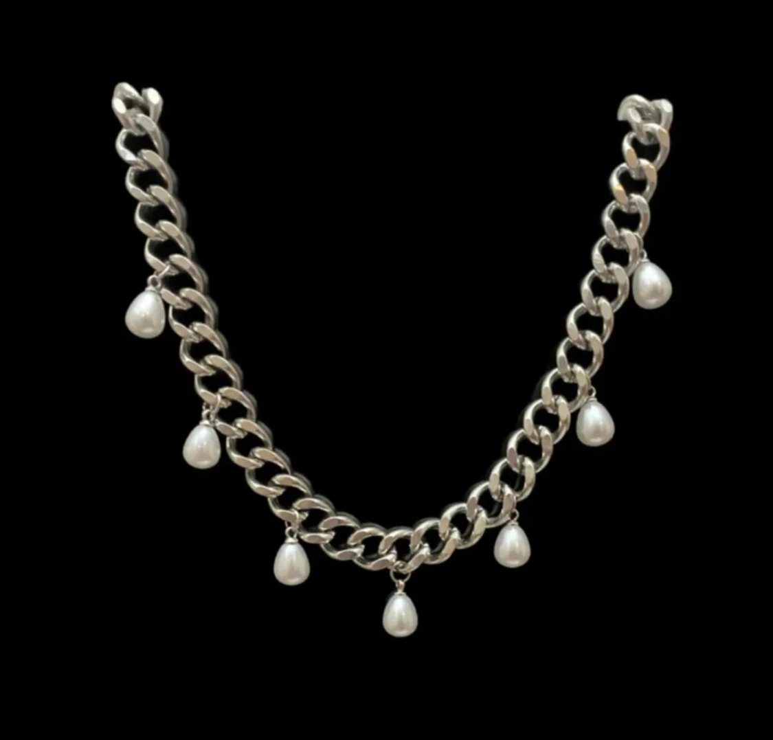 Silvrigt halsband med droppformade pärlor.