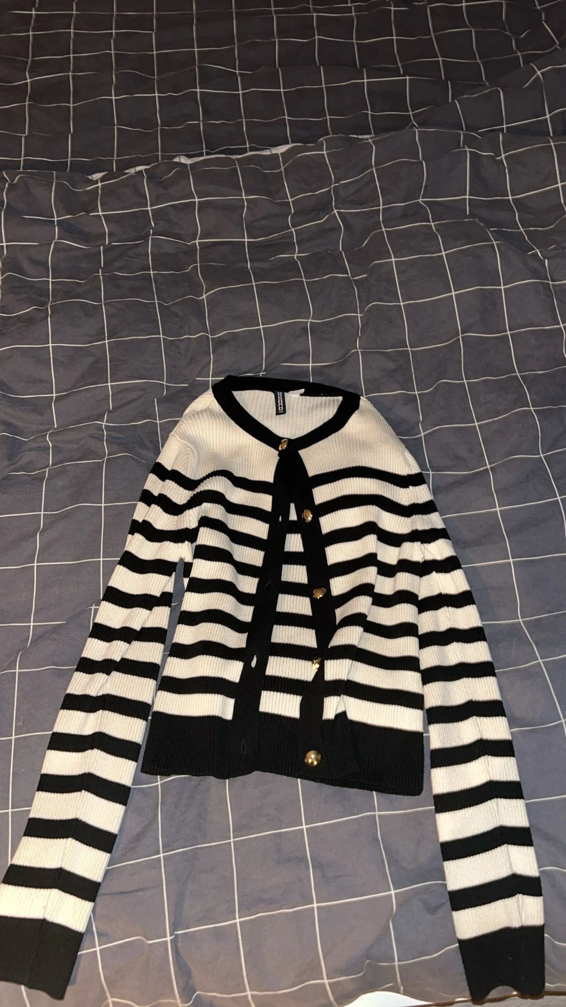 Randig svartvit kofta med guldfärgade knappar