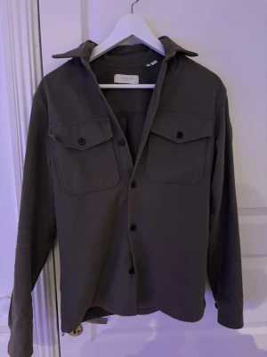 Overshirt  - Mörkgrön overshirt från Jack and Jones i storlek S använd fåtal gånger.