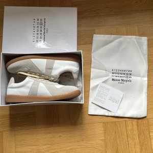 Maison Margiela sneakers i vitt och beige - Maison Margiela – helt nya och aldrig använda! Strl 43. Nypris ca 6000 säljer för 1600 . Så fina men blev fel storlek för mig. Passar dig som vill ha något både unikt, tidlöst och sjukt snyggt. Pris ej hugget i sten.
