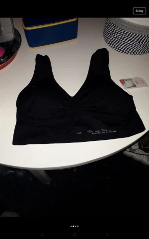 Svart och vit sömlös linnetopp M - Två sömlösa linnetoppar i storlek M, en svart och en vit. Båda har breda axelband, v-ringning och lätt vaddering för extra stöd. Tillverkade i stretchigt material som sitter skönt mot kroppen. Perfekta för en chill och sportig look.50 kr st