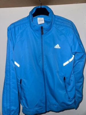 Blå vindjacka från Adidas - Snygg blå vindjacka från Adidas.