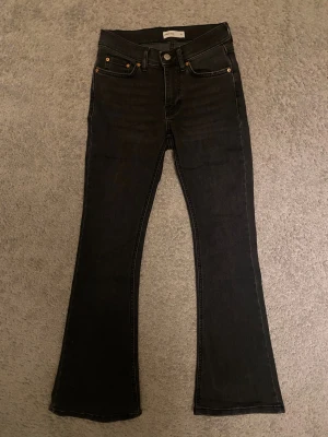 Bootcut jeans Gina tricot - Svartgråa bootcut jeans från Gina Tricot i storleken 32 med låg midja. Jeansen är i modellen perfect jeans petite, alltså lite kortare. Använda enbart några fåtal gånger och inga tecken på användning. Passar ungefär dig som är 160 cm lång eller kortare. Frakt tillkommer☺️🥰🌸