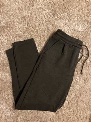 Vero Moda mörkgrå jersey pants - Mörkgrå mjukisbyxor från Vero Moda (VMRORY NW LOOSE STRING JERSEY PANTS NOOS).  I mycket bra skick.   Två stycken fejkfickor baktill. Vanliga fickor framtill.   