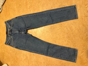 Blå raka jeans från Lee - Snygga klassiska blå jeans från Lee med rak passform och normal midja. Jeansen har fem fickor, Lee-lapp i brunt läder baktill och är gjorda i slitstarkt denim. Perfekta för dig som gillar tidlös stil och enkelhet.köpte för 750kr och säljer för 475kr(pris kan diskuteras)