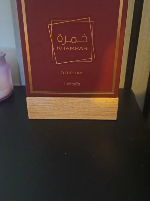 Khamrah Dukhan Eau de Parfum - Khamrah Dukhan från Lattafa är en Eau de Parfum med en volym på 100 ml. Ingredienser: Alcohol denat, Parfum, Aqua, Linalool, Limonene, Hydroxycitronellal, Citral, Coumarin, Geraniol, Benzyl Benzoate, Eugenol, Cinnamal, Cinnamyl Alcohol, Isoeugenol. Snygg flaska som sticker ut i samlingen. Använd ca 5 spray.