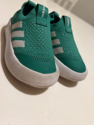 Gröna slip-on sneakers från Adidas - Unisex barn skor inga men bra skick.