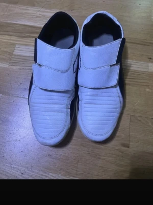 Puma Sport Lifestyle Sneakers - Stylish Puma Sport Lifestyle sneakers in white with black details. Minimalist design with double velcro straps, giving a clean and sporty look. Brand: Puma Size: EU 43 / US 10 / UK 9 / 28 cm Color: White with black accents Condition: Used – good condition Normal signs of wear No major damage (see photos for details) Made in Vietnam Original Puma product (label visible in photos) Comfortable and lightweight – great for everyday wear, street style, or casual outfits. 📦 Ships fast ❌ No original box