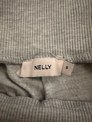 Grå mjukisbyxor från Nelly, S - Snygga grå mjukisbyxor från Nelly i storlek S. Byxorna har en bred ribbad midja som ger extra komfort och en clean look. Materialet är mjukt och stretchigt, perfekt för chill dagar. Passar dig som gillar enkel och stilren design.
