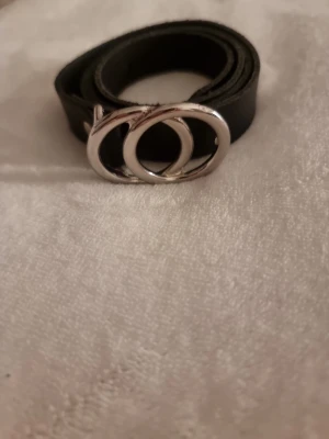 Skärp - Det är ett svart skärp med en silver detalj på den är använd max 3 gånger och den är i väldigt bra skick.