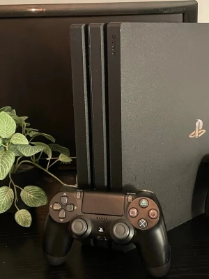 PlayStation 4 Pro - Sony PlayStation 4 Pro med original DualShock 4-kontroll. Konsolen är i gott skick med mindre yttre slitage. Perfekt för gaming i 4K och HDR. Flera anslutningsmöjligheter på baksidan. Kontrollen fungerar och har normala tecken på användning. Kabel ingår med en extra DualShock kontroll 