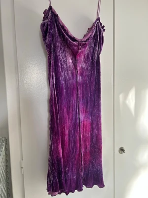 Acne Studios Lila och rosa kortklänning i sammet - Supersöt kortklänning från Acne Studios i mjuk sammet med lila och rosa toner. Klänningen har smala axelband, volangkant upptill och knytning fram.  Den saknar lappar men är köpt i gruppen LWL på facebook. Uppskattar storleken till S Länk för fler bilder på modellen:   https://www.mytheresa.com/ch/it/donna/acne-studios-miniabito-in-velluto-floccato-viola-p00807988?slink_id=842715b4-e41d-43c3-b095-5dc22ac9c54f