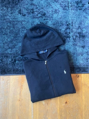 Mörkblå Ralph Lauren zip up Hoodie  - Hej! Säljer en mörkblå Ralph Lauren Zip up hoodie. Den är i storlek M och har inga defekter. Hör av er vid frågor!