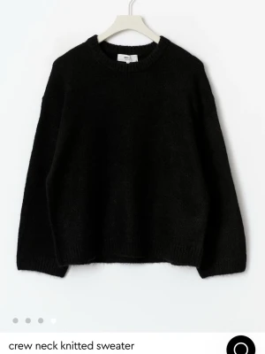 Svart stickad tröja från gina - Mysig svart stickad tröja från gina med rundad hals och ribbade muddar. Tröjan har en loose passform och långa ärmar, perfekt för lager-på-lager under kyliga dagar. Materialet är mjukt och ger en skön känsla mot huden. skriv för fler bilder 