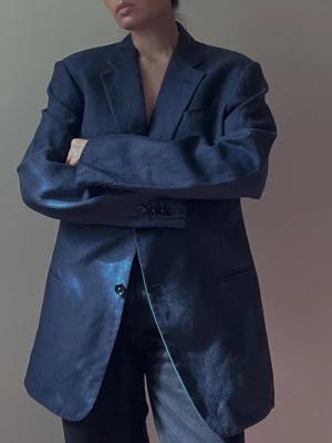 Vintage Armani Linen Blazer Blue - Vintage 2 Buttoned Armani Collezioni Blazer with Lining. Linen Blend in Navy Blue color. 3 Frontal Pockets, 2 Inner Pockets. Made in Portugal. Original Tagged Size Men's 52R. Best Worn Oversized. A small spot in the back that has an irregular weave, see image for reference. Overall Very Good Condition.  Model is 160cm (5”3) and generally fits S/M.  79 CM/ 31.1 IN Length 63 CM/ 24.8 IN Sleeve 45 CM/ 17.7 IN Shoulders 92 CM/ 36.2 IN Chest 90 CM/ 35.4 IN Waist  62%Linen 38%Wool