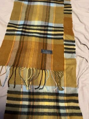 Ljusbrun burberry scarf - Säljer denna snygga scarfen från burberry. Scarfen är perfekt för dig som gillar en klassisk tidlös stil.  Priset är ej hugget i sten!