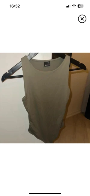 Olivgrön linnetopp från Gina Tricot - Säljer en enkel och stilren olivgrön linnetopp från Gina Tricot i storlek M. Toppen är ärmlös med rund halsringning och har en tight passform. Perfekt att matcha med jeans eller shorts för en chill look.