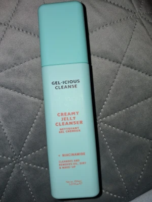 Gel-icious Cleanse Creamy Jelly Cleanser - Fräsch ansiktsrengöring i en ljusblå, rektangulär plastflaska med pump. Innehåller niacinamid och aloe vera för att jämna ut hudtonen och minimera porer. Passar perfekt för att ta bort smink, olja och smuts. Volymen är 150 ml.