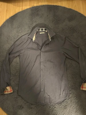 Burberry skjorta  - Säljer denna sjukt feta burberry skjorta. Storlek S och grå, skjortan är använd men fortfarande i bra skick så finns lite små tecken på användning. Självklart äkta. Hör av dig vid minsta lilla fundering! 