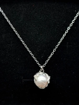 Handgjort halsband inspirerat av Maria Nilsdotter  - Stilrent handgjort halsband inspirerat av Maria Nilsdotter. Naturlig havspärla och ett hänge på 1,5 cm. Kedja av rostfritt stål, nickelfri och allergivänlig.