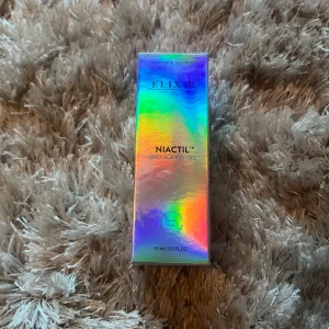 Elixir Niactil Anti-Age Eye Gel - Säljer en Elixir Niactil Anti-Age Eye Gel i en snygg holografisk förpackning. Gelen kommer i en 15 ml tub och är speciellt framtagen för området runt ögonen. Perfekt för dig som vill boosta din hudvårdsrutin med något extra.