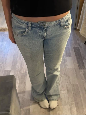 Ljusblå bootcut jeans från H&M Divided - Säljer ett par ljusblå jeans från H&M Divided i storlek 40. Jeansen är lågmidjade och har en snygg tvättad look med ljusa toner💗