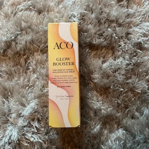 ACO Glow Booster serum - ACO Glow Booster är ett serum med hög dos av vitamin C och hyaluronsyra. Förpackningen är gul och orange med svart text. Serumet ger glow, jämnar ut hudtonen och minskar pigmentfläckar. Passar alla hudtyper och skyddar mot fria radikaler.