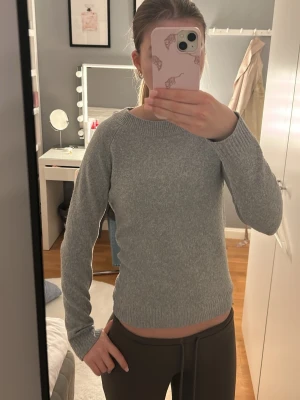 Grå stickad tröja från Vero Moda XS - Mysig grå stickad tröja från Vero Moda i storlek XS. Tröjan har rund halsringning, ribbade muddar och är långärmad. Perfekt för lager-på-lager och enkel att matcha med jeans eller kjol.
